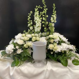 White floral centerpiece with a goblet vase on a draped table