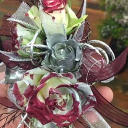 Small hand-held corsage with burgundy and silver roses