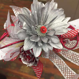 Silver artificial flower corsage with red ribbon accents