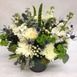 White and green floral arrangement in a dark vase