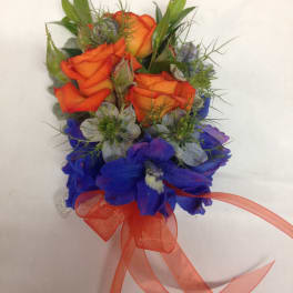 Orange roses with blue flowers and a ribbon bow