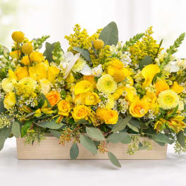 Yellow floral arrangement in a rectangular wooden box
