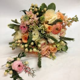 Pastel bouquet of roses and ranunculus with berries and greenery