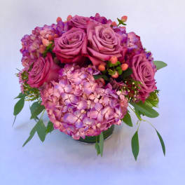 Pink roses and hydrangeas arranged in a low glass vase