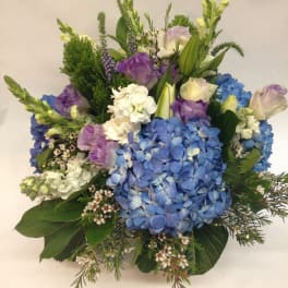 Bouquet of blue hydrangeas, purple blooms, and white flowers