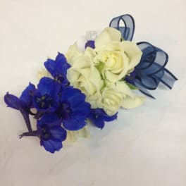 Small bouquet of white roses and blue flowers tied with ribbon