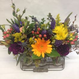 Colorful mixed flower arrangement in a metal basket