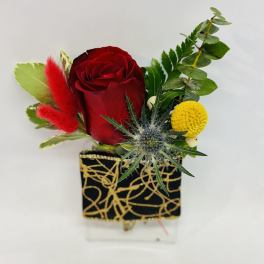 Red rose arrangement in a black and gold square vase