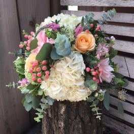 Mixed bouquet with cream hydrangeas, peach roses, and pink flowers
