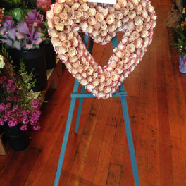 Heart-shaped floral arrangement on a blue easel stand