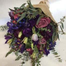 Bouquet of purple and pink flowers wrapped in burlap