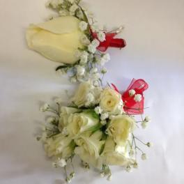 Two ivory rose bouquets with baby's breath and red ribbon accents