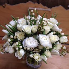 White rose bouquet in a glass vase with berry accents