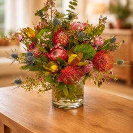 Mixed bouquet of pink and red flowers in a clear glass vase