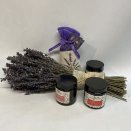 Bundle of dried lavender with three black-lidded jars and a purple sachet