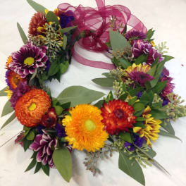 Colorful flower wreath with a magenta ribbon bow