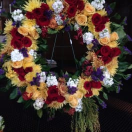 Large floral wreath with red and yellow roses and white accents