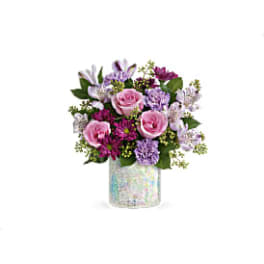 Pink and lavender flower arrangement in a iridescent vase