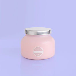 Pink jar candle with a silver lid on a lavender background