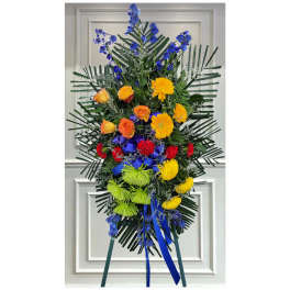 Tall standing floral spray with blue, yellow, red, and green flowers