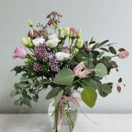 Pink and white bouquet in a clear glass vase with eucalyptus