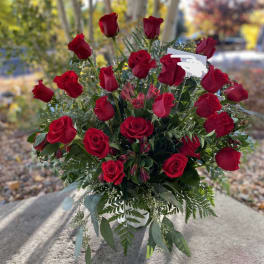 Bouquet of red roses with greenery in a white vase