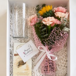 Gift box with a small bouquet, glass vase, and chocolate truffles