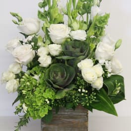 White roses and green flowers arranged in a wooden box