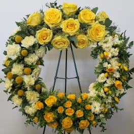 Yellow and white floral wreath on a stand