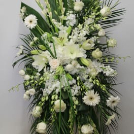 Large white funeral spray with lilies, roses, and gerbera daisies