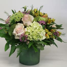 Bouquet of pale pink roses and green hydrangeas in a green vase