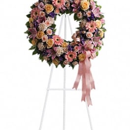 Floral wreath on a standing easel with a pink ribbon bow