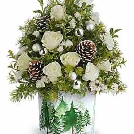 White roses and pinecones in a clear square vase