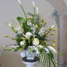 Tall white floral arrangement with yellow accents in a white vase
