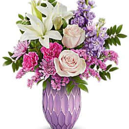 Pink and white floral arrangement in a purple vase