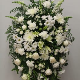 Large white funeral spray with roses, chrysanthemums, and lilies