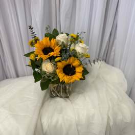 Bouquet of sunflowers and white roses in a glass vase