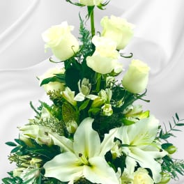 White roses and lilies in a tiered floral arrangement