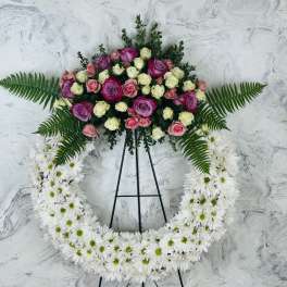 Standing floral wreath with pink and white roses and white daisies on an easel