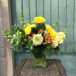 Yellow and cream mixed bouquet in a clear glass vase