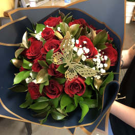 Bouquet of red roses with white filler and a butterfly decoration