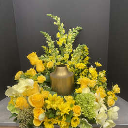 Yellow floral arrangement around a gold urn