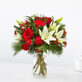 Red roses and white lilies in a clear glass vase