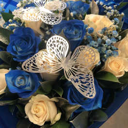 Blue and cream roses with butterfly decorations in a bouquet