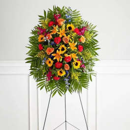 Standing floral spray with bright mixed flowers on a black easel
