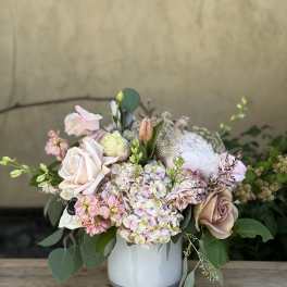 Pastel flower arrangement in a white vase with roses and hydrangeas