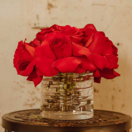 Red roses arranged in a clear glass vase