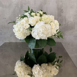 White hydrangea and rose arrangement in a glass vase