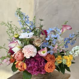 Colorful mixed flower arrangement in a woven basket