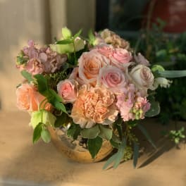 Peach and pink rose bouquet in a round vase